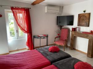 1 dormitorio con 1 cama, TV y silla en Chambres d'hotes Béziers La Noria en Cazouls-lès-Béziers