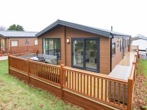 a modular home with a deck and fence at Woodpecker Lodge in Dunbar