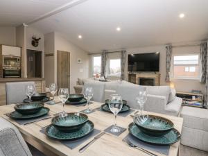 a dining room with a table with plates and wine glasses at Woodpecker Lodge in Dunbar