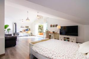 ein weißes Schlafzimmer mit einem Bett und einem TV in der Unterkunft CABOT in Sant Andreu de Llavaneres