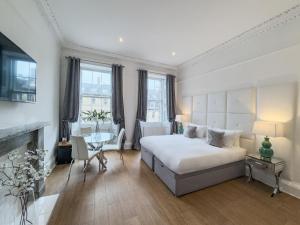 a bedroom with a bed and a table and a fireplace at Hanover 71 Suites in Edinburgh