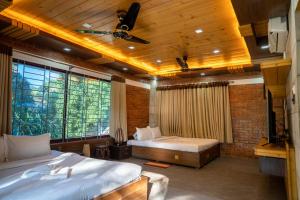 een slaapkamer met 2 bedden en een groot raam bij Lemon Garden Resort & Spa in Sreemangal