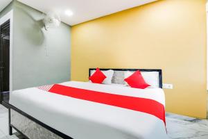 1 dormitorio con 1 cama grande con almohadas rojas en OYO Flagship Aadya Greens en Juhi Bari