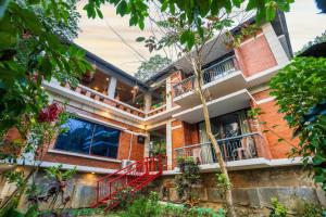 a brick house with red stairs and balconies at Lemon Garden Resort & Spa in Sreemangal