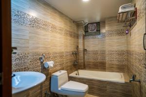La salle de bains est pourvue de toilettes, d'un lavabo et d'une baignoire. dans l'établissement Lemon Garden Resort & Spa, à Sreemangal