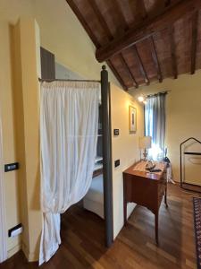 a room with a bed and a desk and a window at La Corte di Ronzano in Scarperia