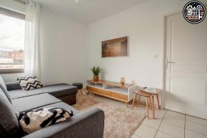 a living room with a couch and a table at rouen gare logement avec parking in Rouen