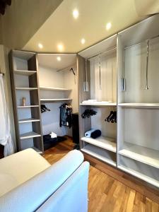 a walk in closet with white shelves and a couch at La Corte di Ronzano in Scarperia