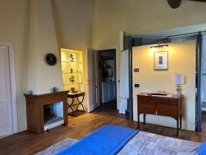 a bedroom with a bed and a dresser and a fireplace at La Corte di Ronzano in Scarperia