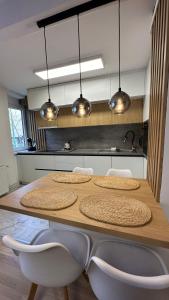 a kitchen with a table with chairs and lights at Sarajevo Charm Apartment in Sarajevo