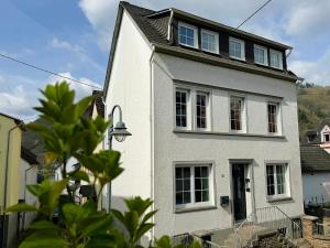 a white house with a black roof at Ferienwohnungen Bullay in Bullay