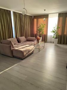 uma sala de estar com um sofá e uma mesa em Caprice Deluxe Accomodation em Drobeta-Turnu Severin