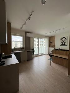 a large room with a large kitchen with wooden floors at Apartament Pileckiego 7b/15 in Suwałki