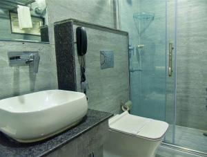 a bathroom with a toilet and a sink and a phone at HOTEL APOLLO GRAND A UNIT OF SATYAM ASSOCIATES in Guwahati