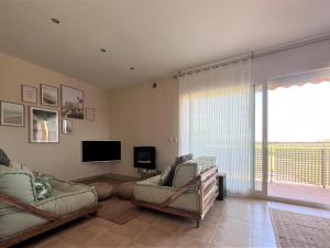 a living room with two chairs and a tv and a window at Apartamento Sant Pere Pescador, 2 dormitorios, 5 personas - ES-89-110 in Sant Pere Pescador