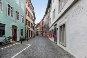 an empty street in a city with buildings at Historika in Konstanz