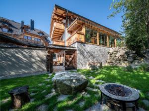 a wooden house with a fire pit in a yard at Tatrachalet Lomnica Rent in Vysoke Tatry - Tatranska Lomnica.