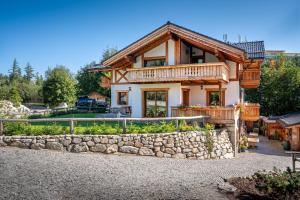 a house with a stone wall in front of it at Tatrachalet Lomnica Rent in Vysoke Tatry - Tatranska Lomnica.