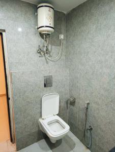 a bathroom with a toilet and a light on the wall at Airport KINGDOM in New Delhi