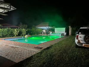 un coche estacionado al lado de una piscina por la noche en Finca El Duero, en Guamal