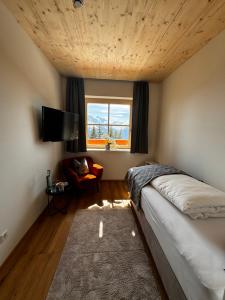 a bedroom with a large bed and a window at GLOCKNERALM in Zell am See