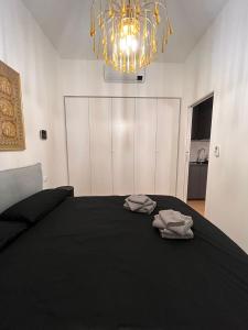 a bedroom with a black bed with two towels on it at Trieste Centrale Luxury Apartament in stile moderno in Trieste
