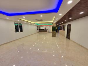 a large room with a tile floor and a blue ceiling at SAROJINI GARDEN HOTEL & RESTAURANT in Begusarai