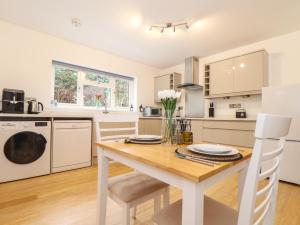 a kitchen with a wooden table and white appliances at Lakeside in Falmouth
