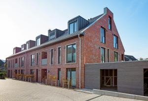 un grande edificio in mattoni rossi con finestre su strada di Haven Fan Frede a List