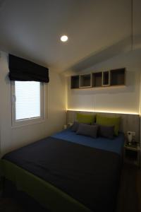 a bedroom with a blue bed and a window at Mobilheim Summer Lounge Appartment I in Borgdorf-Seedorf