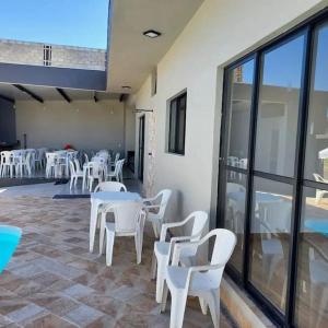 a group of white tables and chairs in a room at Recanto Shalom desativado in São Carlos