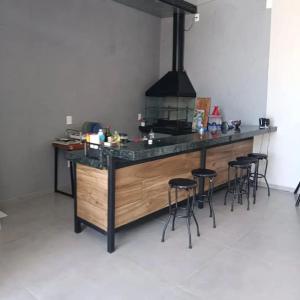 uma cozinha com um balcão com bancos de bar em Recanto Shalom desativado em São Carlos