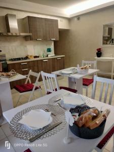 una cocina con mesa y sillas blancas, mesa y sillón en La Casa di GioAna, en Campodipietra