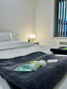 a bed with two bottles of water on a blanket at Rooms Near Me - Apartment 1, Sky Tv, Free Parking 