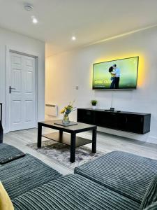 a living room with a tv on the wall at Rooms Near Me - Apartment 1, Sky Tv, Free Parking 