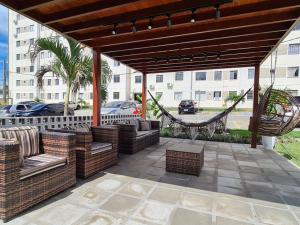 ein Pavillon mit Stühlen und einer Hängematte auf einer Terrasse in der Unterkunft Apartamento em João Pessoa in João Pessoa