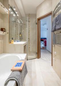 een badkamer met een bad, een douche en een wastafel bij Relaxing Spacious Balcony Super Central Near Opera in Boedapest