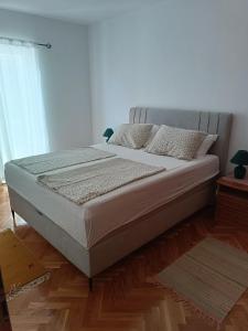 a bedroom with a bed with white sheets and pillows at Promajna apartman in Promajna
