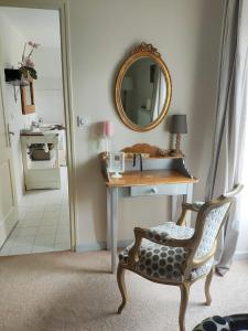 a dressing table with a mirror and a chair in a room at Demeure du Porzou in Yvias +34 photos