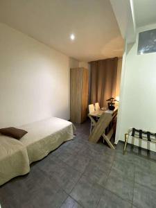 a bedroom with a bed and a table in it at Hotel Citadelle in Béziers