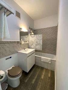 a bathroom with a toilet and a sink and a tub at Hotel Citadelle in Béziers