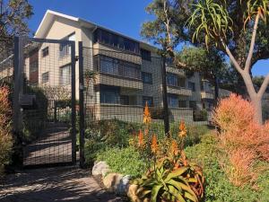 un edificio de apartamentos con una puerta en un jardín en Sundrenched 2 bed 2 bath apartment + sea views en Ciudad del Cabo