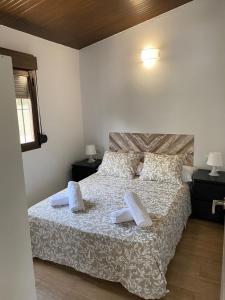 a bedroom with a bed with white sheets and pillows at Casas ROBRA in El Palmar