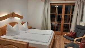 1 dormitorio con 1 cama, 1 silla y 1 ventana en Ferienwohnung Uschi an der Rottachbrücke en Tegernsee