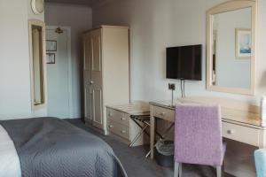 a hotel room with a desk and a bed at Celtic Ross Hotel & Leisure Centre in Rosscarbery