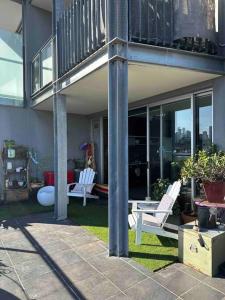 a house with two white chairs and a balcony at You won't believe the balcony! in Melbourne