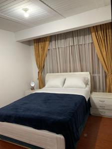 een slaapkamer met een groot bed en een blauwe deken bij CONFORTABLE APARTAMENTO in Bogota