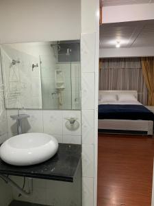 een badkamer met een wastafel en een bed bij CONFORTABLE APARTAMENTO in Bogota