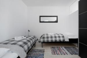 een slaapkamer met 2 bedden en een spiegel aan de muur bij Apartamenty "Bałtyk" Armii Krajowej w Świnoujściu by Renters in Świnoujście
