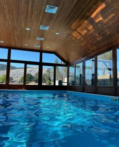 a swimming pool with blue water in a room with windows at Hotel Monte Rosa in Cetinje